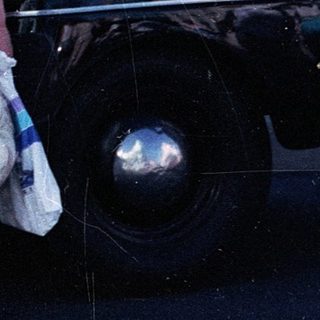 Vintage police car with woman in retro dress posing.