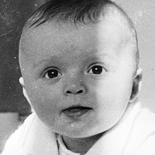 Baby crawling on soft surface indoors.