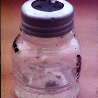 Vintage glass jar with metal lid and spout.