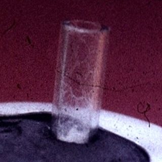 Vintage glass jar with metal lid and spout.