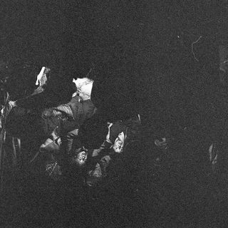 Silhouette of people in dark, nighttime setting.