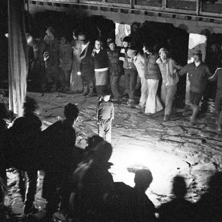 People dancing in dimly lit indoor space.