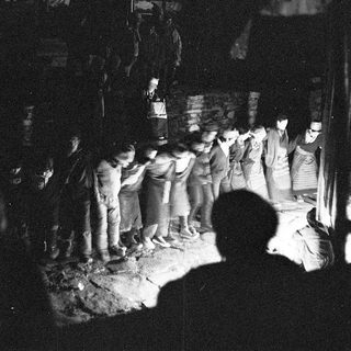 Nighttime festival gathering with traditional banners.