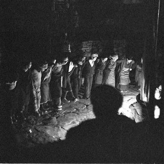 Group gathered around a bonfire at night.