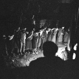 Traditional nighttime procession with illuminated banner.