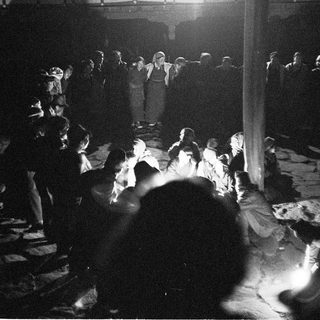 Crowded indoor performance with audience and stage lighting.