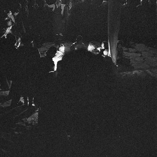 Dark indoor crowd watching stage performance.