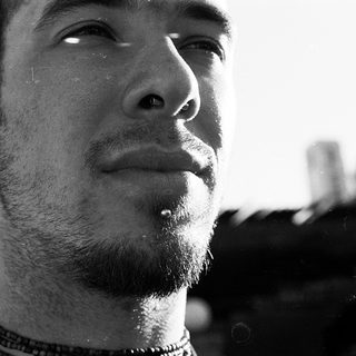 Close-up of a bearded man with facial piercings.
