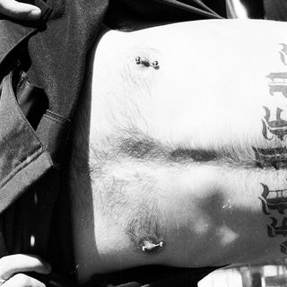Chest with nipple piercings and tattoos.
