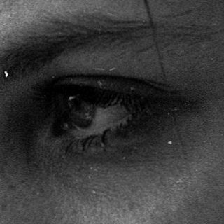 Reflection of woman looking outside rainy window.