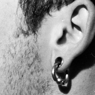 Close-up of person with tongue piercing indoors.