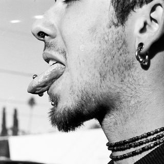 Close-up of person with tongue piercing indoors.