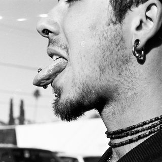 Close-up of person with tongue piercing indoors.