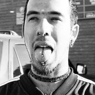 Man with tongue piercing and nose ring.