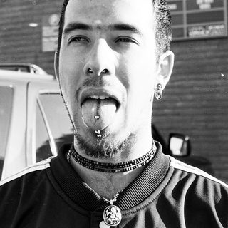 Man with tongue piercing and nose ring.