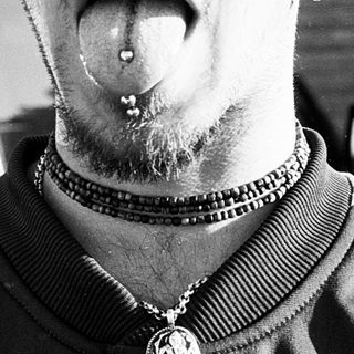 Man with tongue piercing and nose ring.