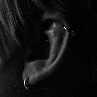 Close-up of person with tear on cheek.