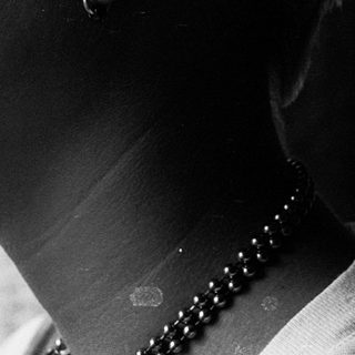 Close-up of person with tear on cheek.