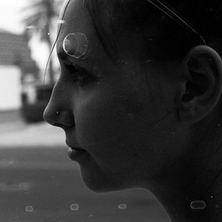 Close-up of person looking out window.