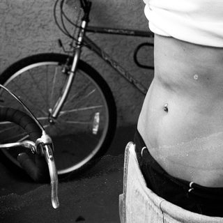 Person riding bicycle with wet, bare lower back.