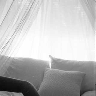 Soft bed with pillows under natural light.