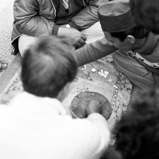 People exchanging money in a traditional barter-like setting.