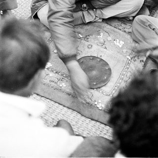 Man playing traditional board game with coins.