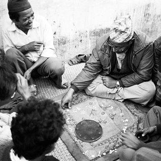 Group playing traditional board game indoors.