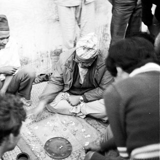 Group of people gathered indoors, likely discussing or attending a traditional ceremony.