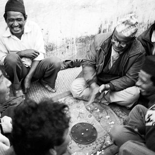 Group of people gathered indoors playing traditional card game.