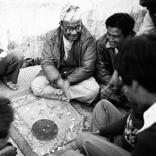 Group playing traditional board game together outdoors.