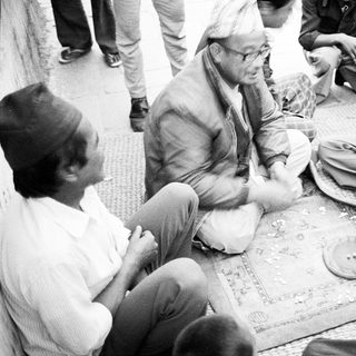 Group of men playing traditional board game outdoors.
