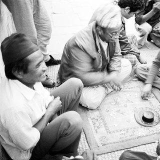 People playing traditional board game together outdoors.