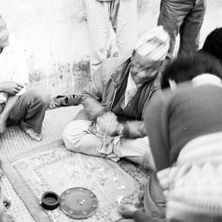 Group of people gathered indoors playing traditional board game.