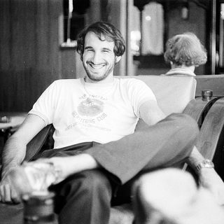 Young man smiling in barber chair.
