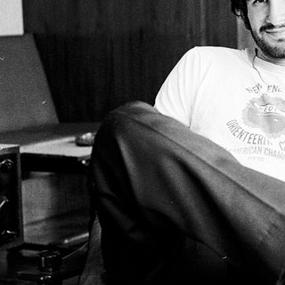 Young man in casual attire posing relaxed indoors.