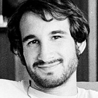 Young man in casual attire posing relaxed indoors.