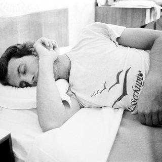 Man resting or sleeping on a bed.