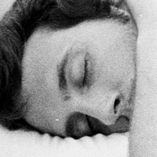Man resting or sleeping on a bed.