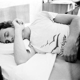 Man resting or sleeping on a bed.