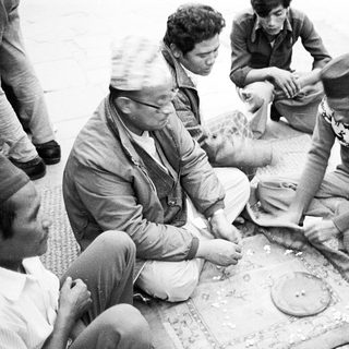 Group playing traditional board game outdoors.