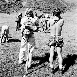 Group hiking with backpacks on rural terrain.