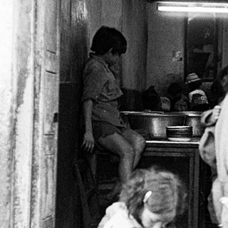Street food stall with man serving food to customers.