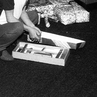 Boy playing with toy train set indoors.
