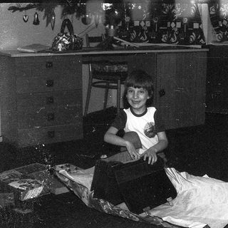 Person sitting indoors on a bed.