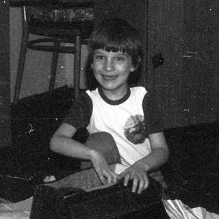 Person sitting indoors on a bed.
