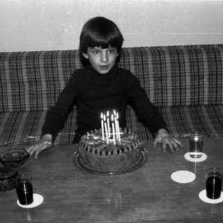 A boy blowing out birthday candles on a cake.