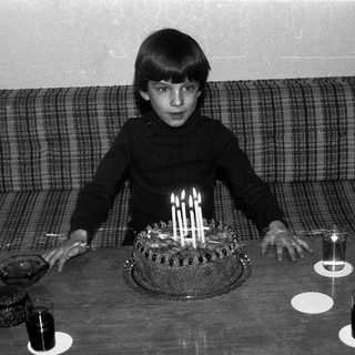 A boy blowing out birthday candles on a cake.
