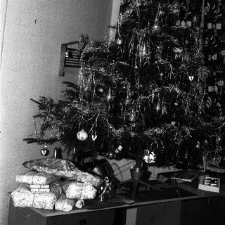 Vintage black-and-white Christmas tree with ornaments and gifts.