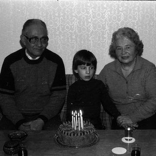 Family celebrating a birthday with cake.